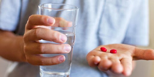 Ảnh con trai tay cầm thuốc cảm màu đỏ