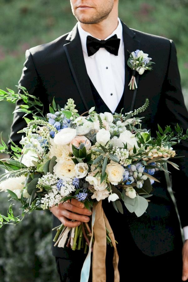 Chú rể trong bộ vest lịch lãm cùng bó hoa rực rỡ