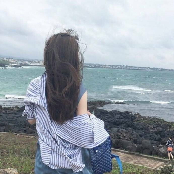 Ảnh chụp từ phía sau lưng con gái tóc dài đứng trước biển đẹp
