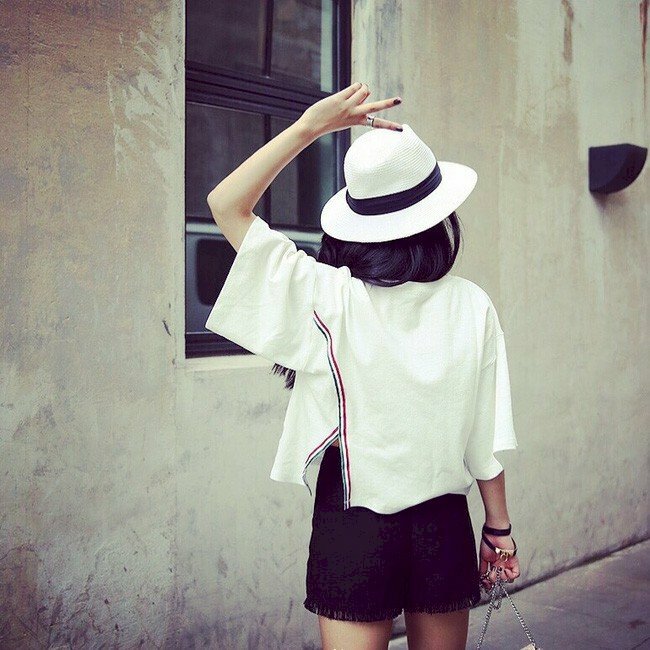 Hình ảnh cô gái tóc ngắn quay lưng giơ 2 ngón tay ra chào