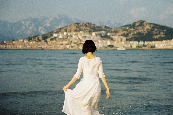 Hình ảnh cô gái tóc ngắn quay lưng đi bộ ra biển