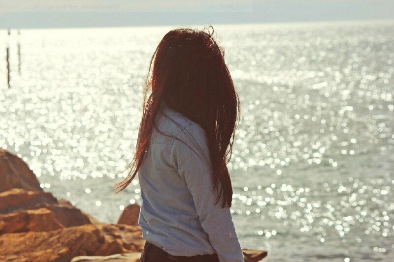 Cô gái ngồi ngắm biển tóc xoã bay trong gió thật đẹp