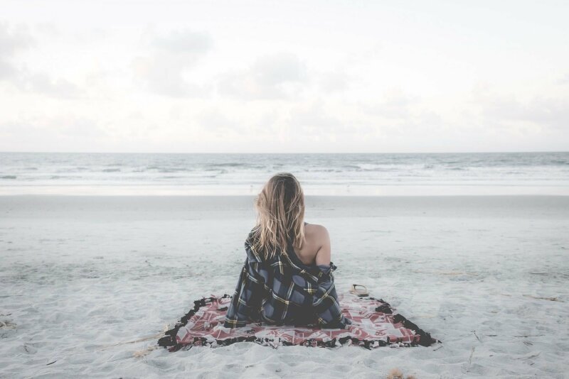 Cô gái xoã tóc ngồi thư giãn trước biển