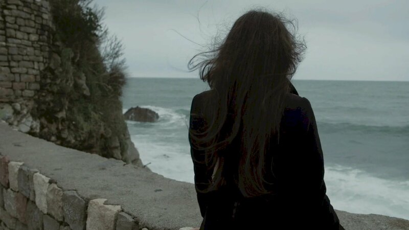 Cô gái với mái tóc dài buồn và cô đơn trước biển