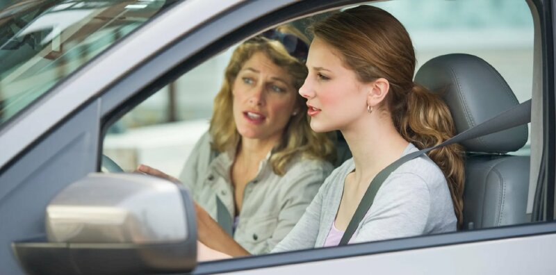 Hình ảnh cô gái trẻ đẹp tập lái ô tô dưới sự hướng dẫn của nữ giáo viên dạy lái