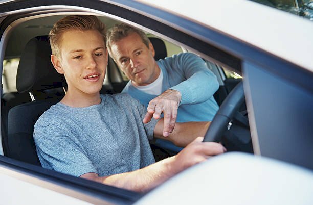 Hình ảnh cậu nam học viên tập lái xe ô tô và Thầy dạy lái xe tận tình chỉ bảo