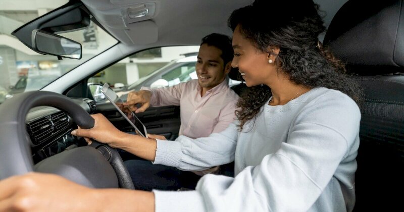 Hình ảnh người phụ nữ đang xem các bài sa hình và thực hành lái xe ô tô