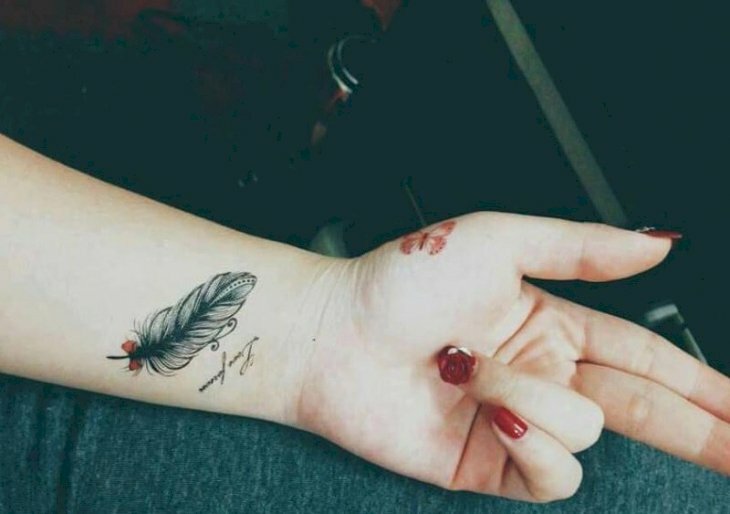 Hình xăm lông vũ có chữ ở cổ tay nữ đầy nghệ thuật