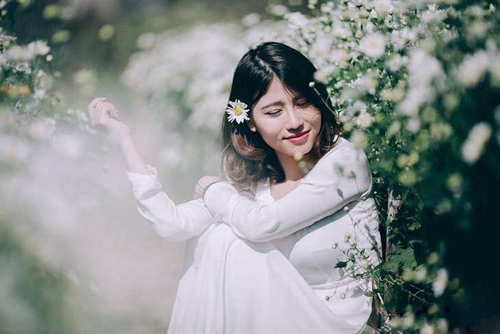 Cách tạo dáng với áo dài cho người béo khi ngồi với góc chụp ngang lấy từ phần thắt lưng lên với dáng ngồi hơi ôm gối,  chếch ống kính một góc 45 độ, cười mỉm, cúi nhẹ đầu sẽ giúp nàng mập có 1 bức ảnh thon gọn hơn.