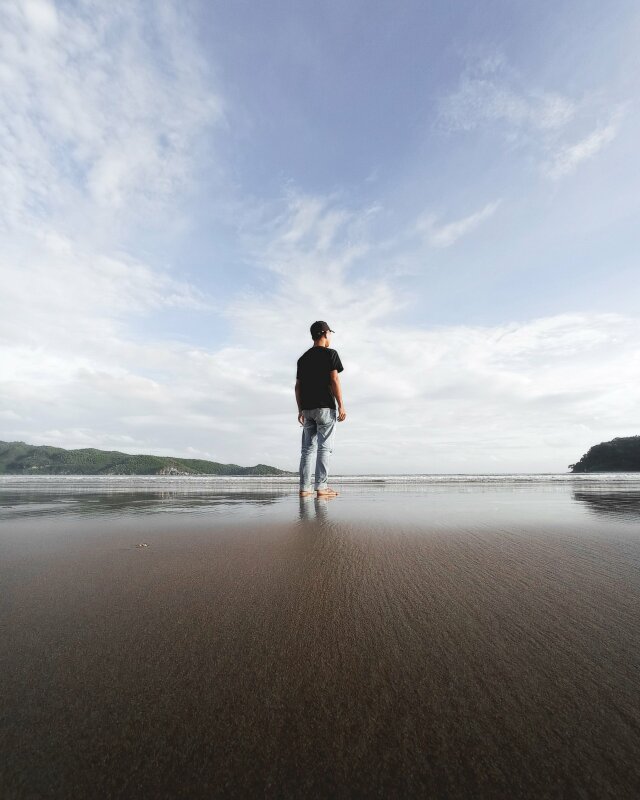 Cách tạo dáng chụp ảnh ngoại cảnh trong kiểu chụp ảnh đẹp xuất sắc với dáng đứng thẳng tự nhiên chụp từ sau lưng lấy full cảnh bầu trời và bãi cát ướt