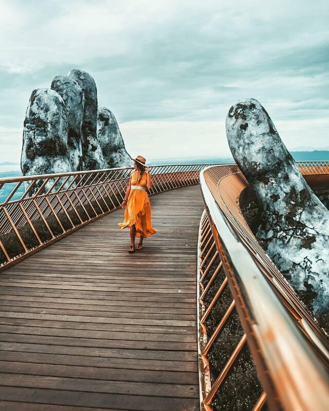 Cách tạo dáng chụp ảnh ở cầu Vàng đơn giản bằng cách đứng trước 1 bàn tay khổng lồ, hãy đứng ra giữa cầu, đưa 1 chân bước lên phía trước, 1 chân bước sau, 1 tay đưa lên cầm nón, nghiêng đầu nhìn qua 1 bên, như vậy bạn đã có 1 tấm hình đang bước đi trên cầu lấy trọn được 1 bàn tay đưa lên nâng đỡ cầu. 