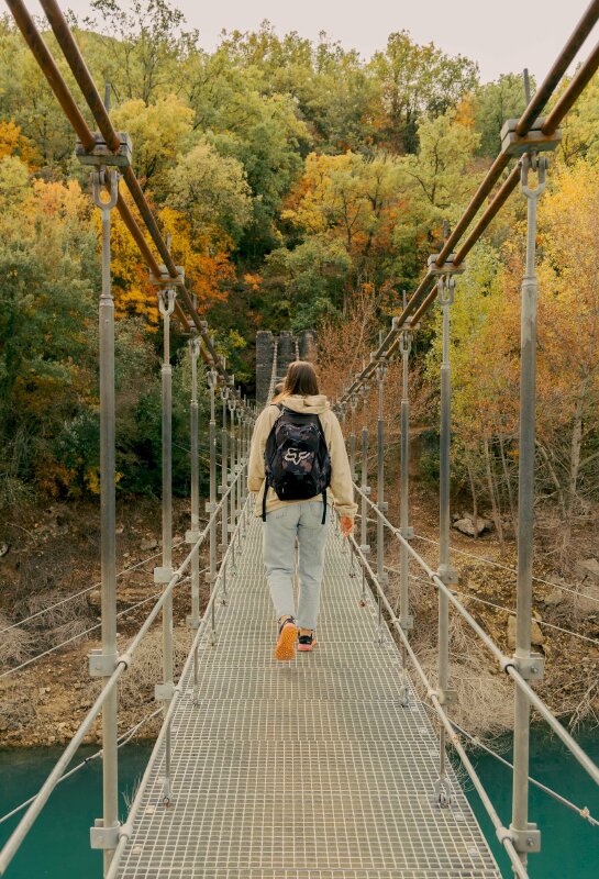 Tạo dáng chụp ảnh trên cầu với tư thế bước đi tự nhiên vai mang balo thể hiện tinh thần mạnh mẽ dám bước tới chinh phục