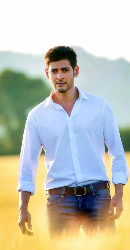 Tạo dáng đứng rất tự nhiên giữa cách đồng 2 tay xuôi thẳng miệng vười nhẹ, mắt nhìn lệch so với ống kính