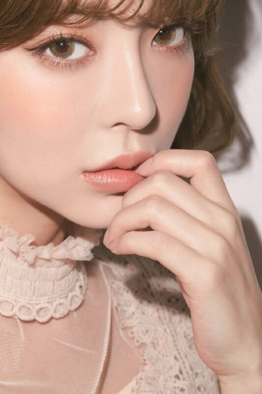 Kiểu chụp ảnh cuốn hút với góc chụp nghiêng, tay chạm lên môi, mát nhìn nghiêng về ống kính