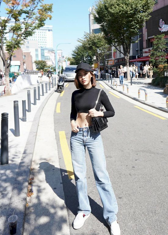 Với outfit áo croptop đen tay dài kết hợp cùng chiếc quần jean ống suông và đôi giày sneaker, nàng hãy đứng dang rộng chân bằng vai, đặt 1 chân hơi bước lên trước, 1 chân sau, đẩy nhẹ hông về phía chân sau, 1 tay đặt ngay thắt lưng để tạo được dáng chụp ảnh ngầu chất mang đậm phong cách street style