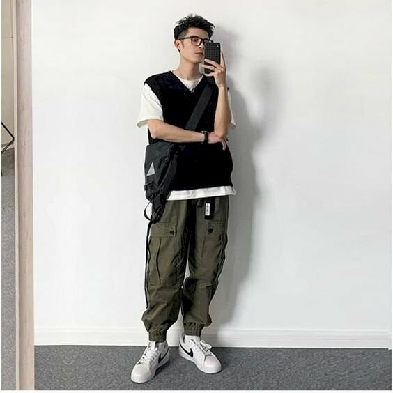 Outfit năng động, trẻ trung với áo thun bên trong áo gile bên ngoài kết hợp cùng chiếc quần jogger rộng sẽ giúp bạn nam bớt gầy đi, và khi chụp hình chỉ cần đứng hơi nghiêng người, 1 tay khoan ngang bụng, 1 tay cầm điện thoại đưa lên chụp hình.