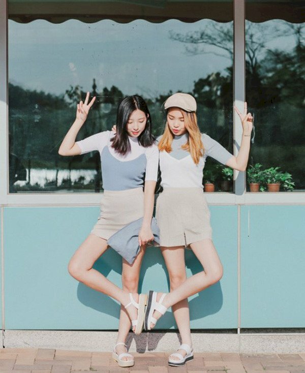 Tạo dáng chụp ảnh đôi bạn thân nữ quay lưng đang đứng trước biển, đưa tay lên ngang vai tạo cảm giác thích thú.