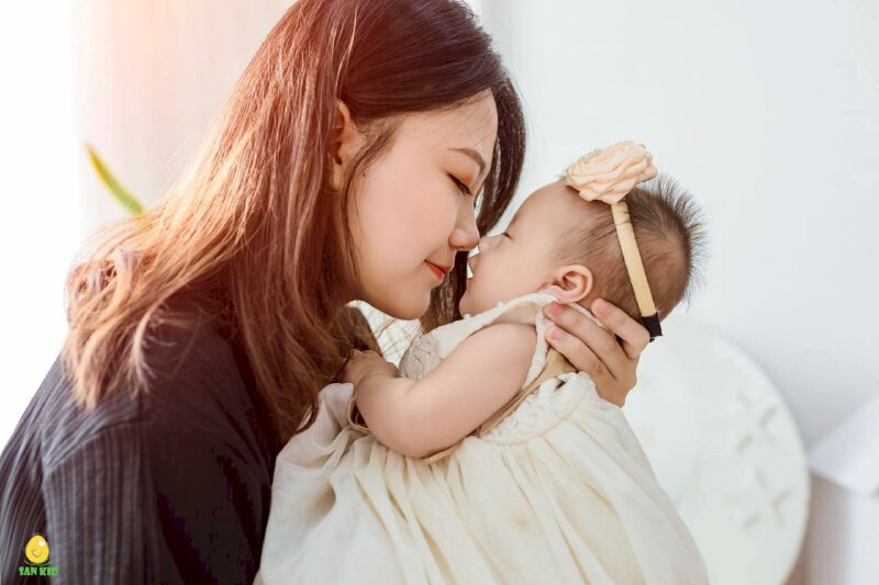 Cách tạo dáng chụp ảnh cho mẹ và bé gái sơ sinh ngọt ngào với kiểu mẹ bồng con đưa mặt con lên sát mặt mình, mắt 2 mẹ con nhắm hờ với góc chụp nghiêng sẽ có được bức ảnh đẹp.