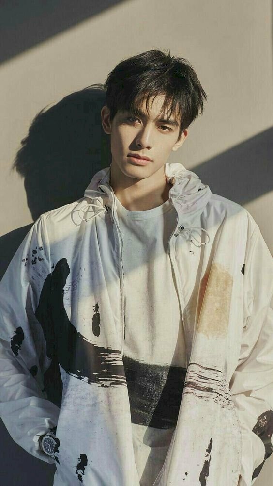 Các kiểu chụp cận mặt nam đẹp, với dáng đứng thẳng dựa lưng vào tường, hai tay cho vào túi áo, đầu hơi nghiêng nhẹ về một bên, ánh mắt nhìn thẳng vào ống kính.