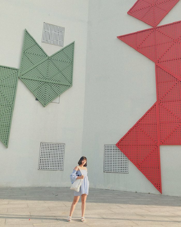 Cách tạo dáng chụp ảnh ở cung văn hóa thiếu nhi ngầu chất ở giữa góc vuông 2 bức tường, hãy đứng 2 ngân rộng bằng vai, đứng trụ trên 1 chân, 1 tay bỏ vào túi quần, và 1 tay đặt lên túi xách đang đeo vai, mặt nghiêng nhìn vào phía ống kính.