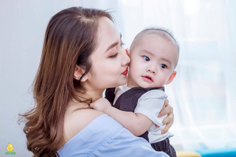 Cách tạo dáng chụp ảnh cho mẹ và bé trai sơ sinh với cách này mẹ hãy bồng ôm con vào người, đặt mặt mẹ nghiêng sát lên má bé.