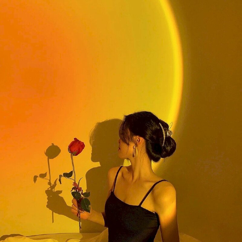 Cách tạo dáng chụp ảnh tại nhà với đèn Led cực kỳ sang chảnh dành cho cô nàng có bờ vai mảnh mai quyến rũ, hãy quay nghiêng nghiêng bờ vai về phía ống kính, mặt quay đi, 1 tay cầm cành hoa hồng đưa lên.