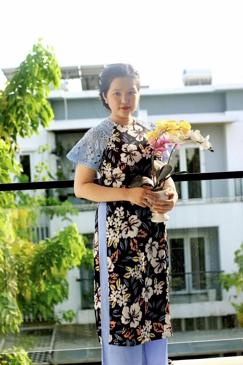 Cách tạo dáng với áo dài cho người béo với chậu hoa lan đặt ngay bụng giúp che đi vòng eo bánh mì, nên đứng chếch ống kính một góc 45 độ, thẳng lưng, cười mỉm, cúi nhẹ đầu.