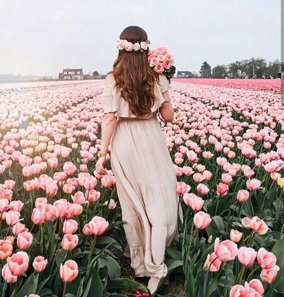 Cách tạo dáng chụp ảnh ở vườn hoa từ sau lưng với kiểu này hãy bước đi với 1 chân trước và 1 chân sau, đầu đội vòng hoa, tay ôm bó hoa đặt trên vai, 1 tay thả lỏng tự nhiên.