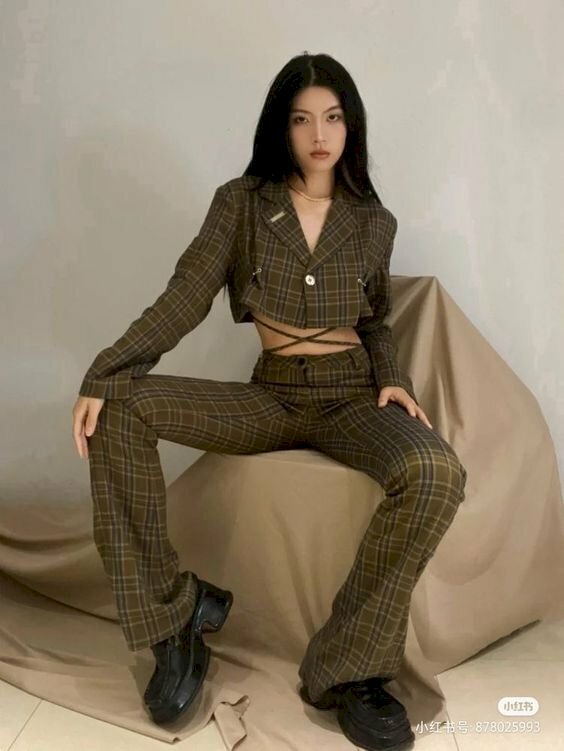 Cách tạo dáng ngồi với vest nữ chất, cá tính ngầu với cách ngồi trên ghế, đặt chân 2 chân 2 hướng, 1 tay để lên đầu gối 1 tay để lên đùi, ngồi hơi nghiêng nhấc 1 vai lên, kết hợp cùng gương mặt lạnh lùng nhìn vào ống kính.