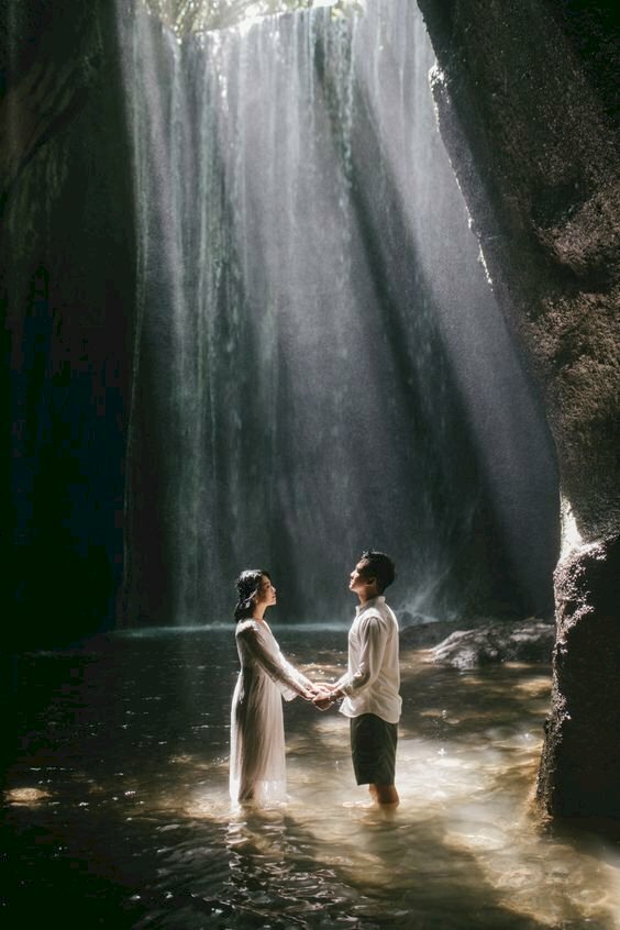 Cách tạo dáng chụp ảnh với thác nước cho cặp đôi dưới ánh nắng mặt trời đang chiếu vào cực kỳ đẹp, với kiểu này bạn nam và bạn nữ đứng dưới nước và nắm lấy tay nhau.  