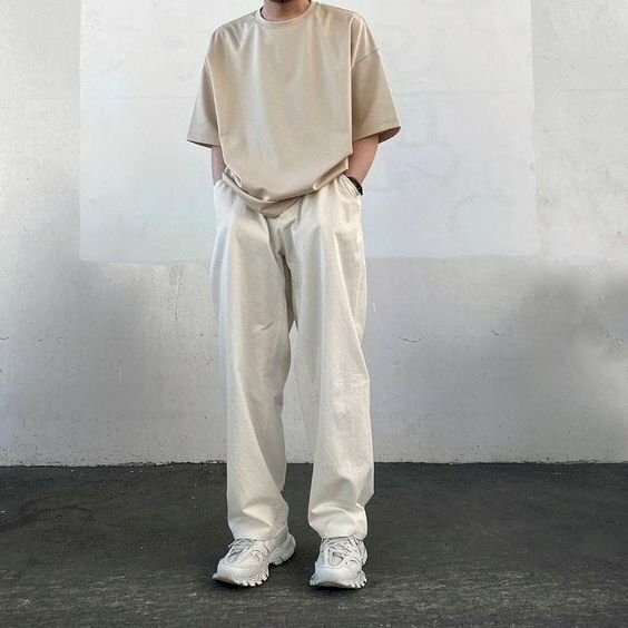 Bạn nam gầy nên lựa chọn trang phục màu trắng sáng, rộng với chiếc ao thun và chiếc quần rộng sẽ giúp tạo sự đầy đặn. Và với trang phục này bạn chỉ cần đứng thẳng, cho hai tay vào túi quần với góc chụp từ dưới lên sẽ giúp tạo nên một bức ảnh đẹp.