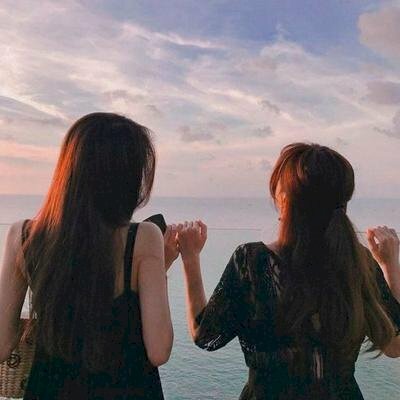 Tạo dáng chụp ảnh đôi bạn thân nữ quay lưng đang đứng trước biển, đưa tay lên ngang vai tạo cảm giác thích thú.