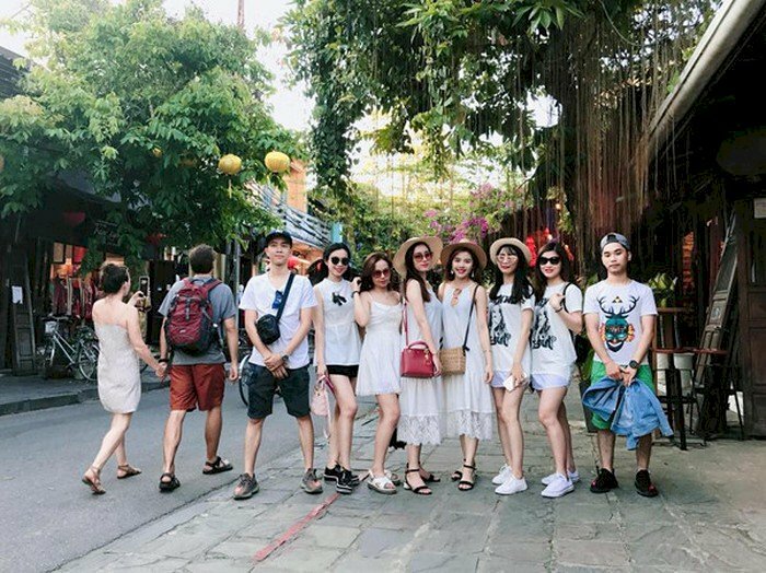 Các kiểu tạo dáng chụp ảnh tập thể ngoài trời đơn giản dành cho nhóm bạn thân, mọi người cùng đứng, nữ sẽ đứng giữa đưa 1 chân trước và 1 chân sau, nam sẽ đứng hai bên.