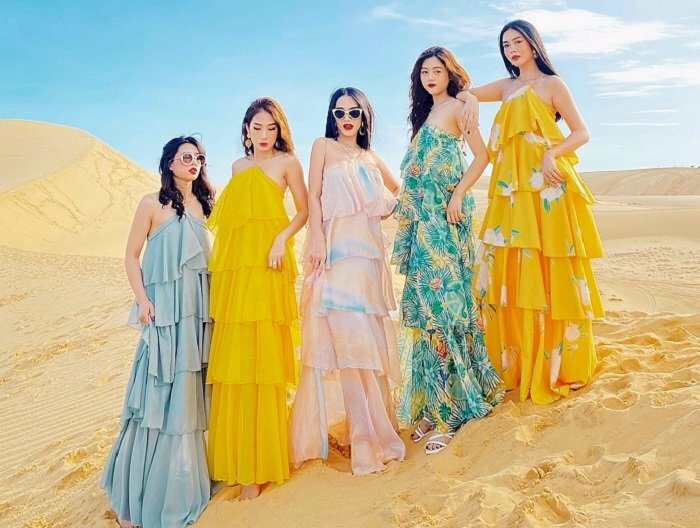 Cách tạo dáng chụp ảnh trên đồi cát cho nhóm bạn thân 5 cô gái mặc váy maxi dài thướt tha, đứng xếp thành 1 hàng ngang, từ thấp đến cao và nhìn vào ống kính.