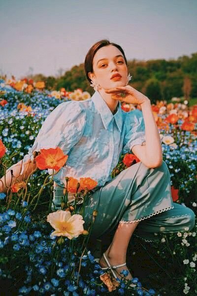 Tạo dáng chụp ảnh ở vườn hoa khi ngồi ở vườn hoa vừa đẹp vừa cá tính với kiểu ngồi xổm, 1 chân thấp 1 chân cao, bạn ngồi vào giữa vườn hoa, đưa 1 tay lên chống nhẹ ở cằm, 1 tay đưa nhẹ sang 1 bên.