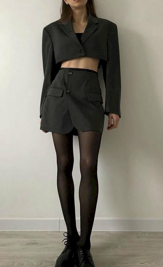 Trong trang phục bộ vest ngắn màu đen, mang đôi tất lưới đen và đôi giày đen, tạo nên sự cá tính cho nữ, với trang phục này hãy đứng dựa lưng vào tường, 2 tay thả lỏng, 1 chân hơi bước lên phía trước.