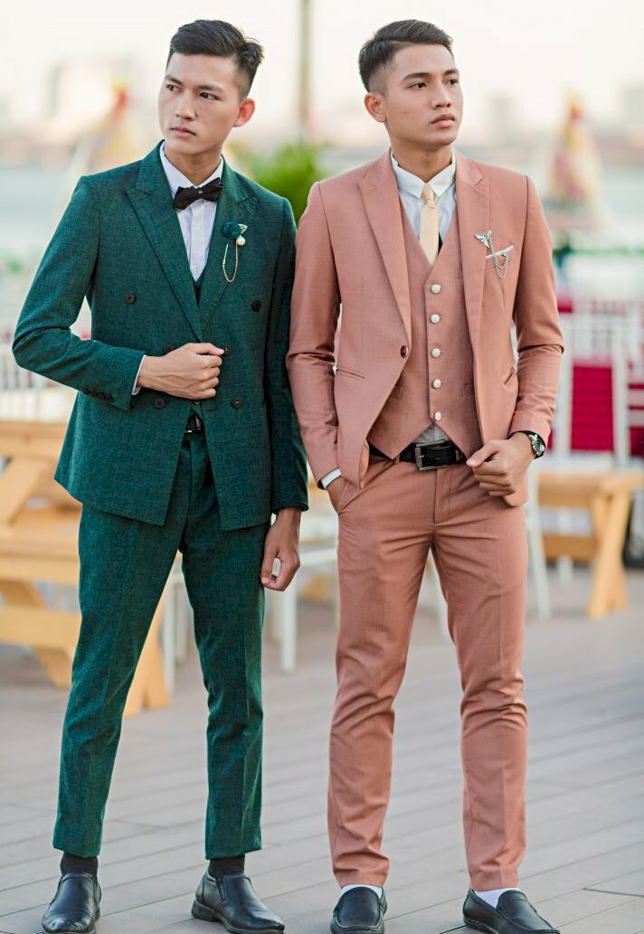 Kiểu dáng nam chụp kỷ yếu thần thái ngút ngàn với 2 nam sinh đứng cạnh nhau trong bộ đồ vest xanh và hồng lịch lãm dáng đứng thẳng tự nhiên