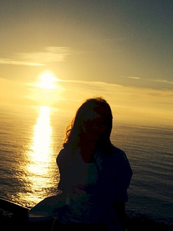 Tạo dáng chụp hình đi biển của nữ ngồi đón bình minh trên biển đẹp chụp từ sau lưng với tư thế ngồi đơn giản