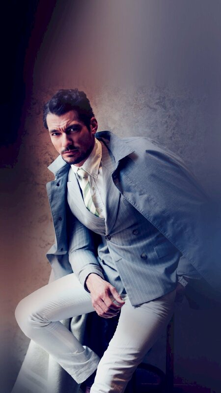 Tạo dáng nam lịch lãm với bộ suit một chân co lại để lên ghế, một chân dũi thẳng