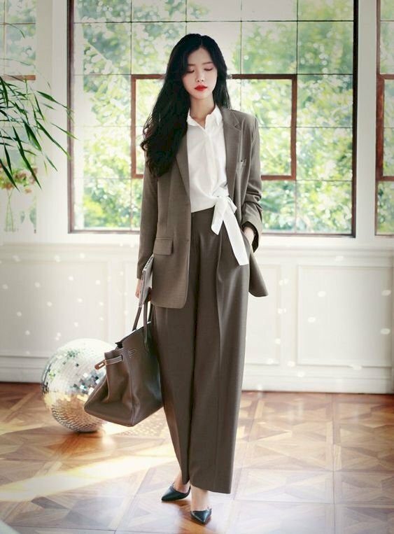 Với bộ vest nâu nhạt dịu dàng, thanh lịch, mái tóc buông dài, nàng có thể thử tạo dáng với 1 chân bước 1 lên trước, 1 chân sau, 1 tay cầm túi xách còn 1 tay bỏ vào túi quần.