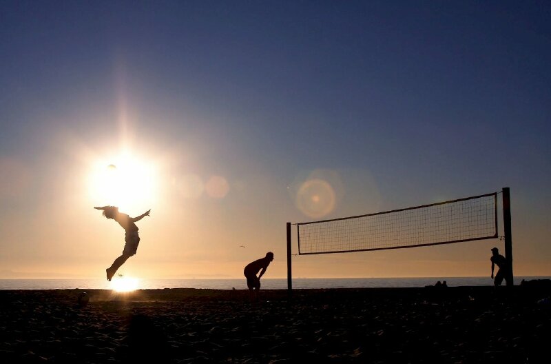 Cách tạo dáng chụp ảnh ở biển siêu đẹp với tư thế co người về phía sau đưa tay chuẩn bị đón bòng dưới ánh mặt trời chói sáng