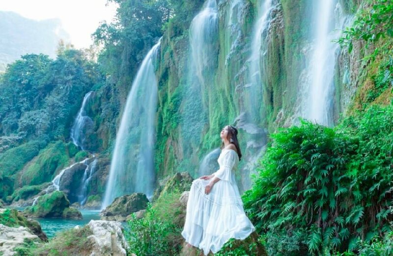 Cách tạo dáng chụp ảnh ngồi trước thác nước đẹp cho nữ, với dáng này hãy ngồi trên tảng đá, đặt 2 tay lên đùi, gương mặt hơi ngước nhìn lên trời.