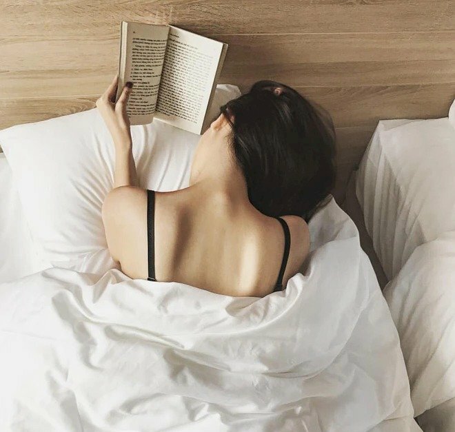 Cách tạo dáng chụp ảnh trong phòng ngủ đơn giản, khoe phần lưng đẹp, chỉ cần nằm úp trên giường, chống người bằng khuỷu tay, trên tay đang cầm 1 quyển sách như đang đọc, tóc để rủ qua 1 bên, với góc chụp từ trên cao xuống.