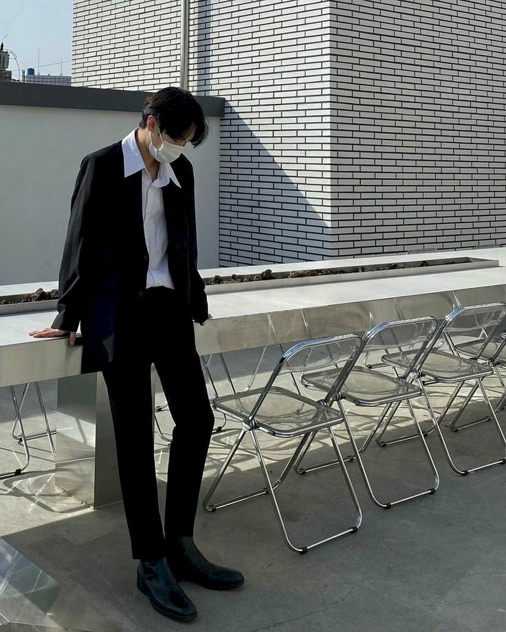 Cách tạo dáng nam thần mang khẩu trang dựa người vào bàn đầu hơi cúi, một chân co nhẹ, 2 tay chống lên bàn