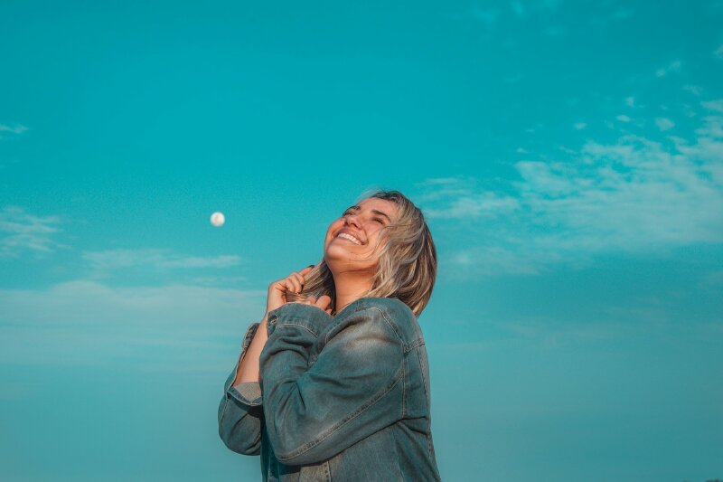 Kiểu tạo dáng chụp từ phía dưới lên lấy full cảnh bầu trời chiều, 2 tay chạm nhẹ tóc, mặt hướng lên cười tươi