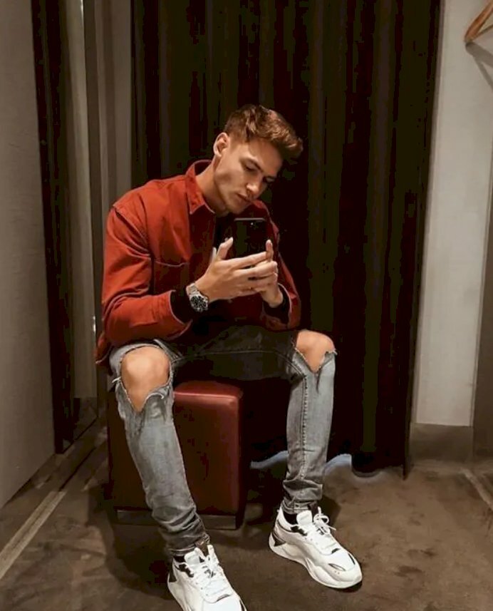 Kiểu tạo dáng đàn ông, kiểu ngồi đầy nam tính với chiếc quần phong cách street style và áo phông đỏ, đầu hơi nghiêng cùng 2 tay cầm điện thoại tự sướng vào gương
