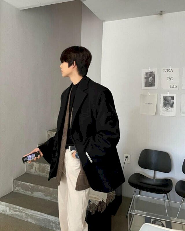 Kiểu tạo dáng nam chụp ở góc nghiêng đầy thần thái trong bộ áo khoán đen, 1 tay đặt túi quần, tay còn lại cầm điện thoại