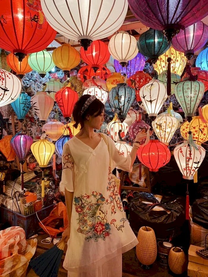 Tạo dáng cô gái trong chiếc đầm trắng tay chạm lồng đen, mặt quay nghiêng tỏa nét dịu dàng