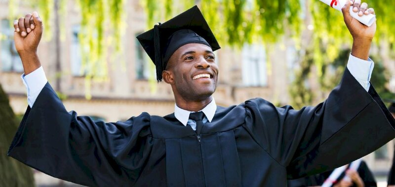 Tạo dáng đẹp chụp ảnh kỷ yếu cho nam trong bộ cử nhân màu xanh với 2 tay đưa lên, đầu ngẩng cao thể hiện sự vui vẻ trong thành công