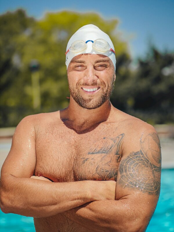 Tạo dáng nam cực hút với gương mặt cươi tươi nhìn thẳng ống kính, 2 tay khoanh trước ngực